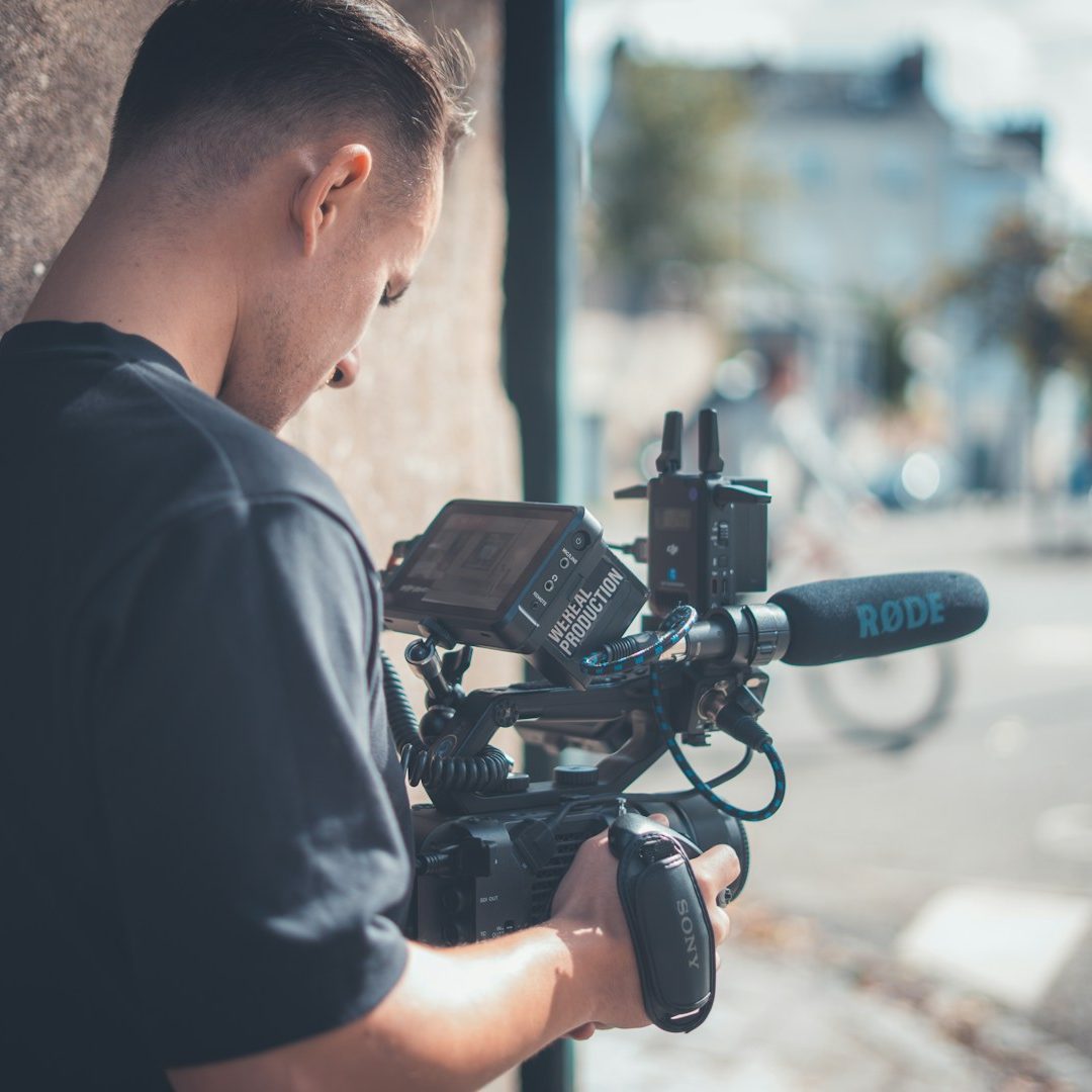 Ein professioneller Videograf filmt mit einer hochwertigen Kinokamera und Røde-Mikrofon direkt vor Ort im Betrieb.